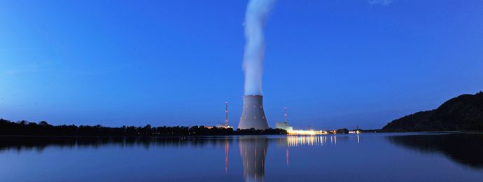 Wasserdampf steigt aus dem Kühlturm eines Atomkraftwerkes in den Abendhimmel auf
